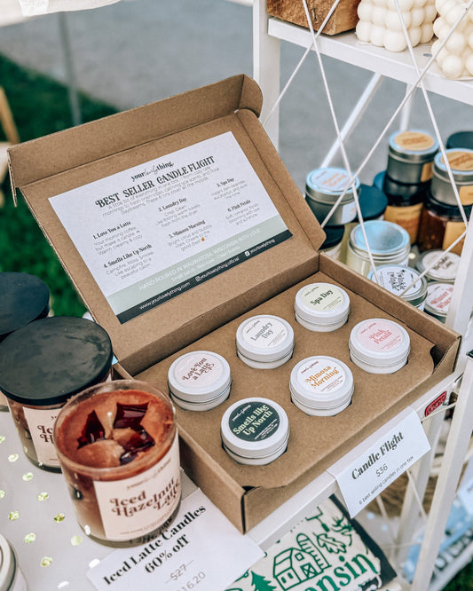 Box of candles with a label on a table with other candles and products.