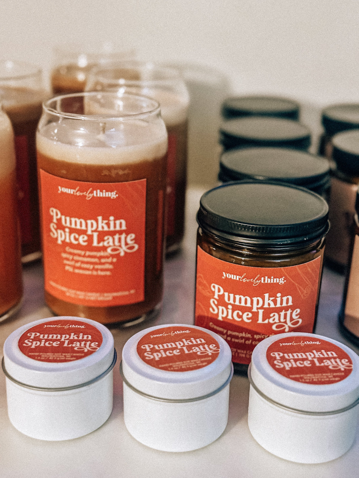 Assorted 'Pumpkin Spice Latte' products including candles and jars on a white surface.