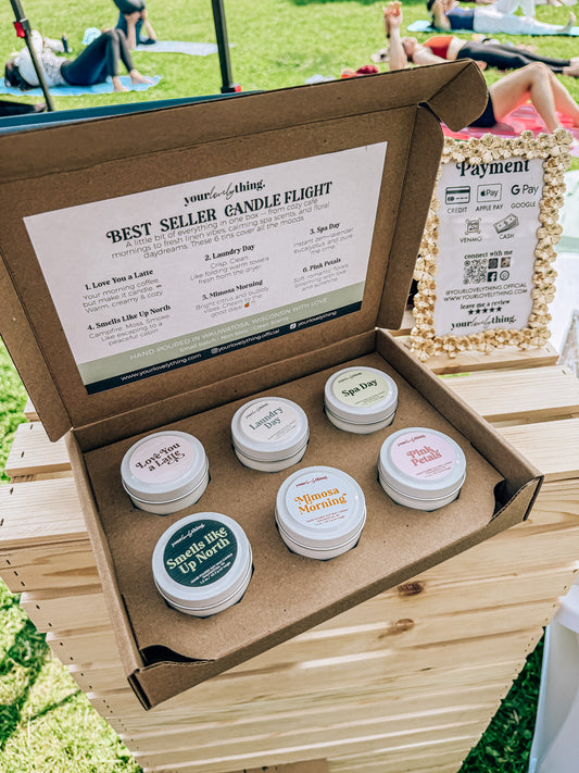 Box of candles with labels on a wooden surface outdoors