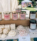 Candles and home decor on display with visible branding at an outdoor event.