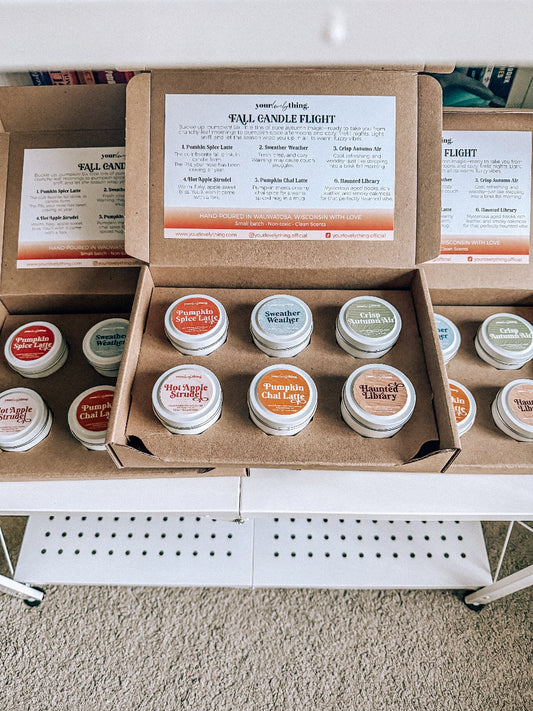 Box of small candles with labels on a white surface